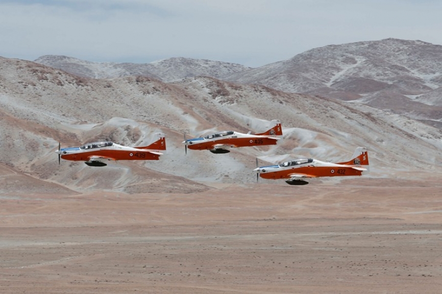 Una Escuadrilla de Aviones de Instrucción Embraer T-27 Tucano, armados con pods FN HMP-250 de 12.7 mm, aproximándose a sus blancos.