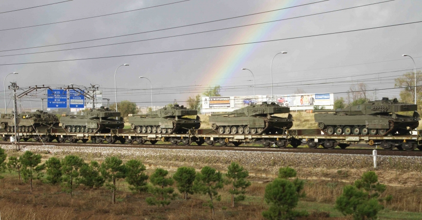Con el arco iris de fondo avanza el tren cargado con carros Leopardo 2E (fotografía Julio Maíz)