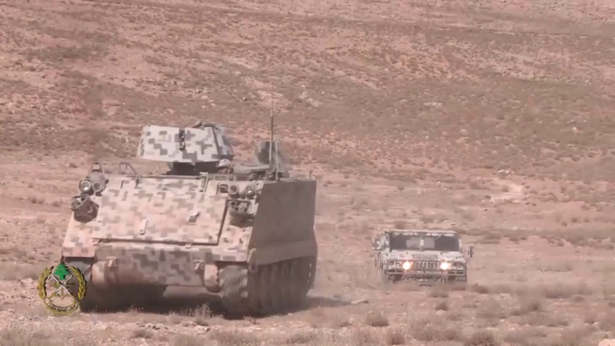 Un M-113, que lleva la protección blindada para el servidor de la ametralladora pesada, avanza seguido de un 4x4 Hummer.