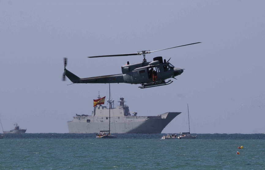 Un AB-212+ hace una pasada junto a la playa, al fondo se ve al Juan Carlos I.Julio Maíz Sanz / defensa.com