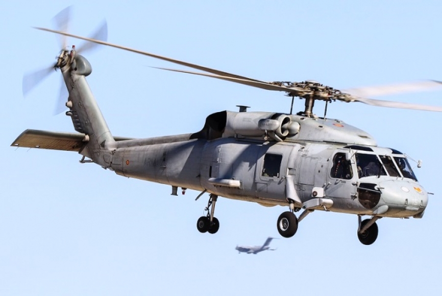 Un SH-60F en vuelo estacionario, debajo de este se ve aterrizando un C.17 de la Fuerza Aérea de Estados Unidos.