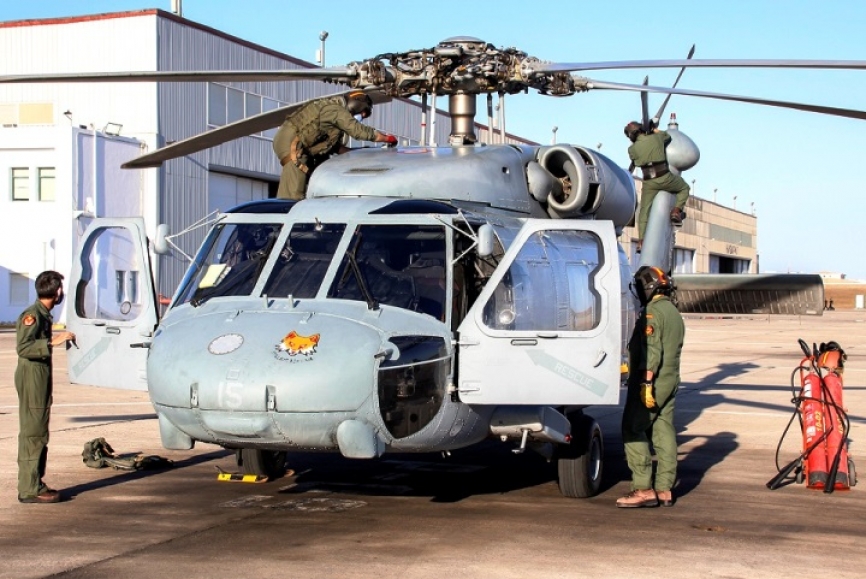 Personal de la Quinta Escuadrilla preparando un SH-60F para una nueva misión