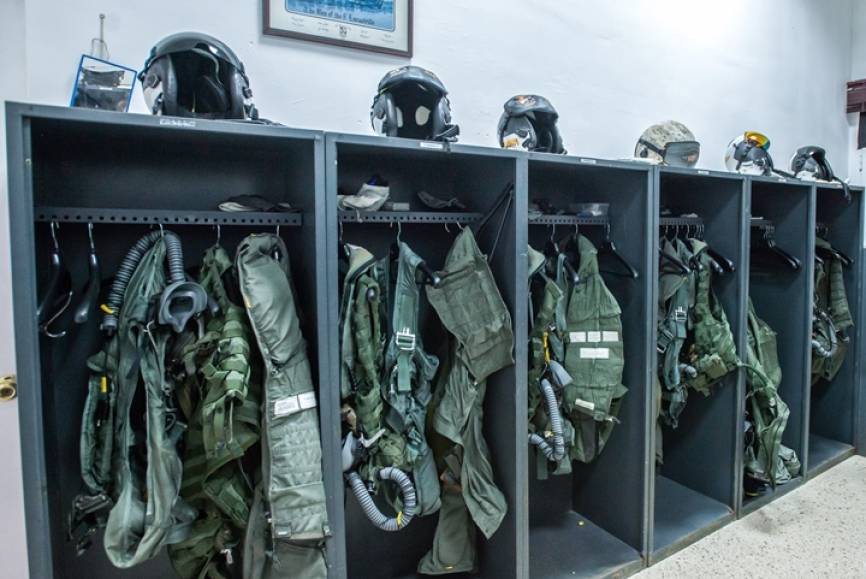 En la imagen vemos las taquillas de los pilotos de la Novena Escuadrilla, donde guardan el casco de vuelo, la máscara, los guantes, el chaleco de supervivencia y el salvavidas, un zahón anti-G y otros elementos indispensables para volar en el Harrier.