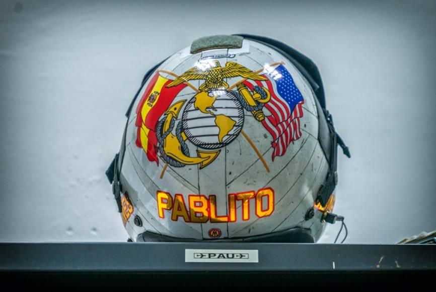 Casco de vuelo HGU-68P perteneciente a Paul “Pablito”, un piloto del Cuerpo de Marines de los Estados Unidos, que ha estado de intercambio en la Novena escuadrilla. Normalmente hay destinado un Marine en España y un Piloto de la Armada Española en USA. El casco de la imagen fue decorado por Sergio Muriel, un artista que también ha decorado otros muchos cascos de la Novena Escuadrilla y otras unidades militares españolas. Este casco muy ligero, solo 998 gramos (sin máscara) y está fabricado con fibras de grafito y aramida. Ayuda a prevenir el G-LOC, protege a la cabeza contra golpes, pero también aísla a los oídos del ruido. La visera protege la cara en el momento de la eyección y posterior caída al mar o tierra firme, y a los ojos contra los deslumbramientos y efectos perjudiciales de los rayos ultravioleta.