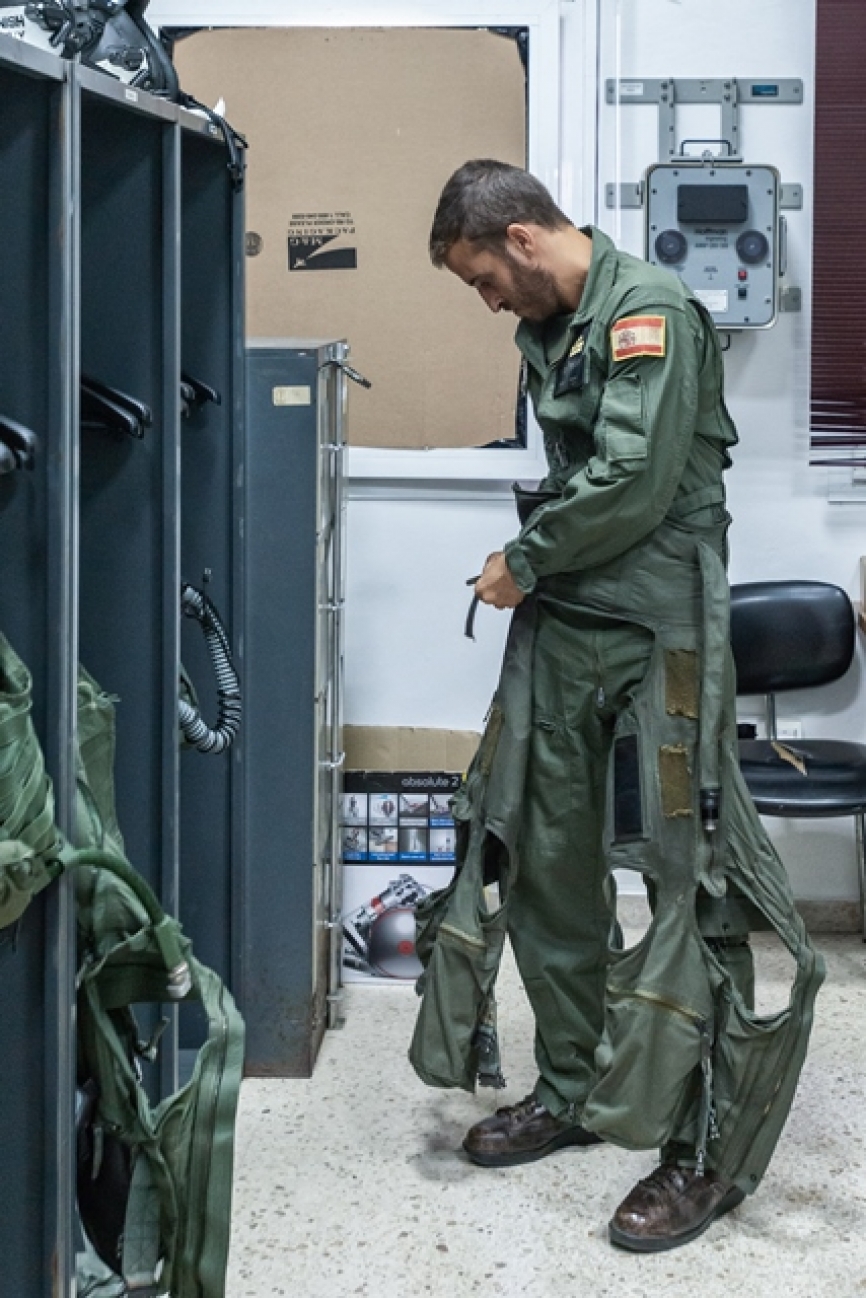 El CSU-13P se empieza a colocar por la cintura. Los “huecos” en la rodilla y parte posterior son necesarios para poder mantener la movilidad de las piernas. El aparato que está sobre la pared es un dispositivo Hoffmann ANV-20/20 y sirve para calibrar las gafas de visión nocturna (NVD).
