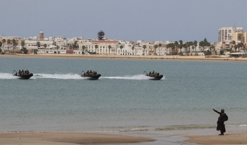 Un infante de Marina de la fuerza de reconocimiento señaliza la zona de desembarco de la primera oleada de la operación anfibia.