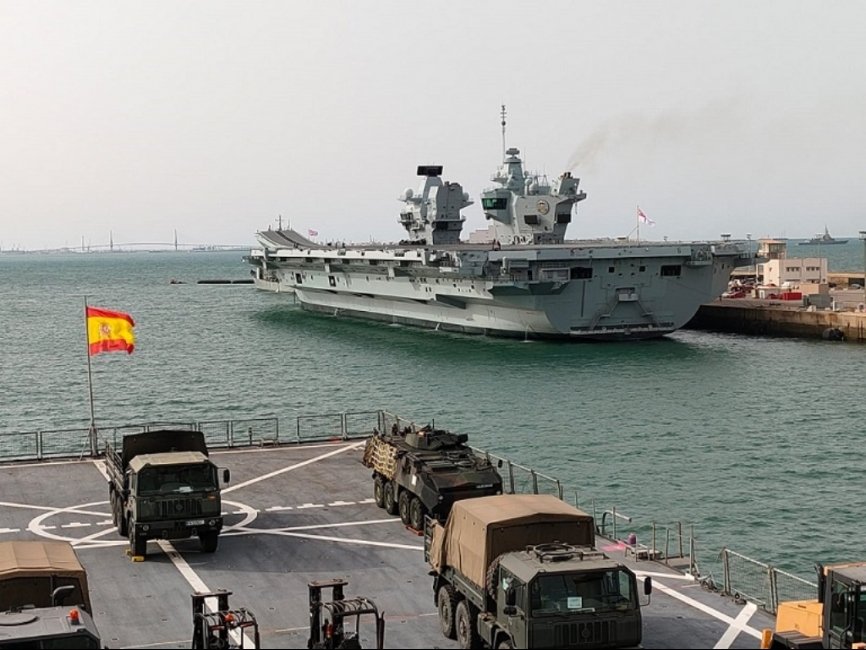 El “Prince of Wales” saliendo de la base de Rota, en primer plano la cubierta del navío anfibio español “Castilla”.