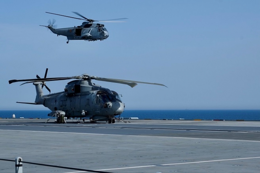 Un helicóptero español “Sea King” sobrevuela el “Prince of Wales”, en cuya cubierta vemos un Leonardo “Merlin”.