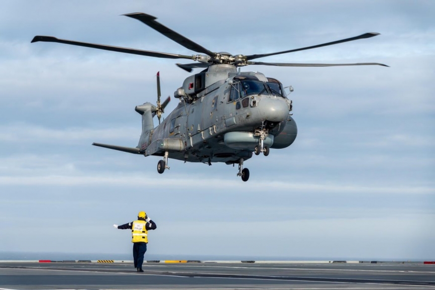 Personal de cubierta dirige la toma en el “Prince of Wales” de un helicóptero Leonardo “Merlin” de su versión “Crowsnest”.