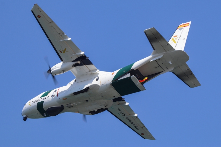Pasada del Airbus Defence & Space CN235 de la Guardia Civil, sacando una bandera de España por la rampa.