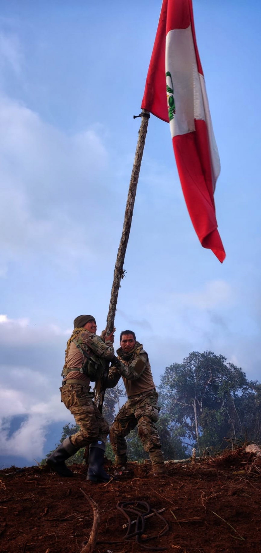 Dos efectivos de la Fuerza Especial Conjunta (FEC) izan la bandera del Perú en el campamento principal de Víctor Quispe Palomino (a) José, líder de la facción disidente de Sendero Luminoso, denominada Militarizado Partido Comunista del Perú Marxista-Leninista-Maoísta (MPCP- MLMPM), en la Zona de Vizcatan del Ene.