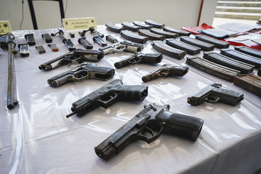 En primer plano una pistola Star 30M y una Glock 17 de 9 mm. Atrás, más pistolas de 9 mm. y 380 ACP, así como un variopinto grupo de cacerinas de pistolas y fusiles de asalto.