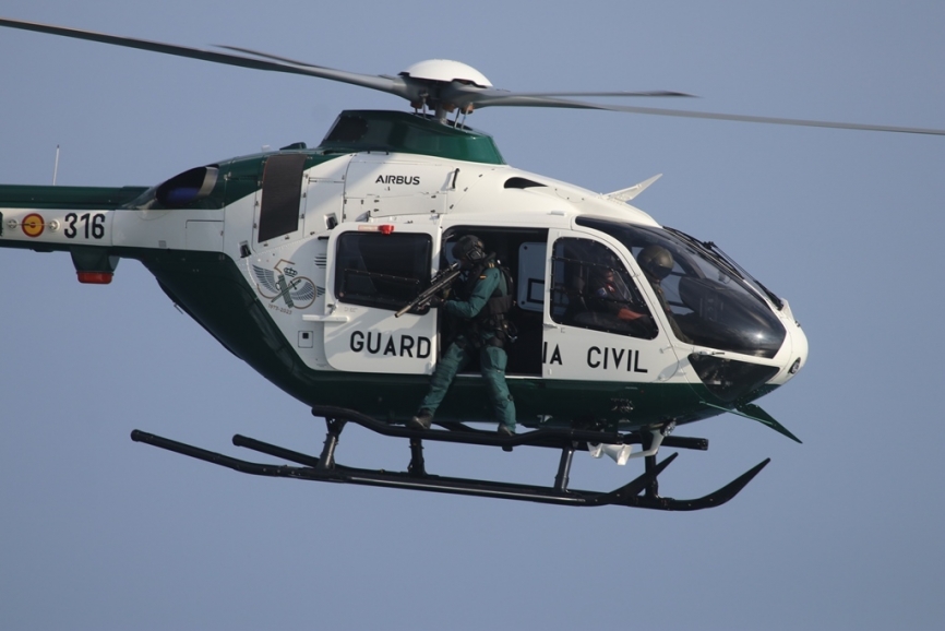 Un helicópteros H135 volando rasante, en la puerta un agente de la UEI apunta a los “narcotraficantes” con su fusil HK-417. (Julio Maíz)