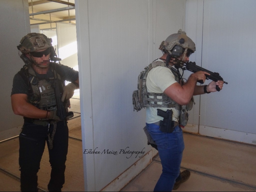 Dos operadores de un equipo especializado en operar en zona gris con vestimenta de civil limpiando una habitación.