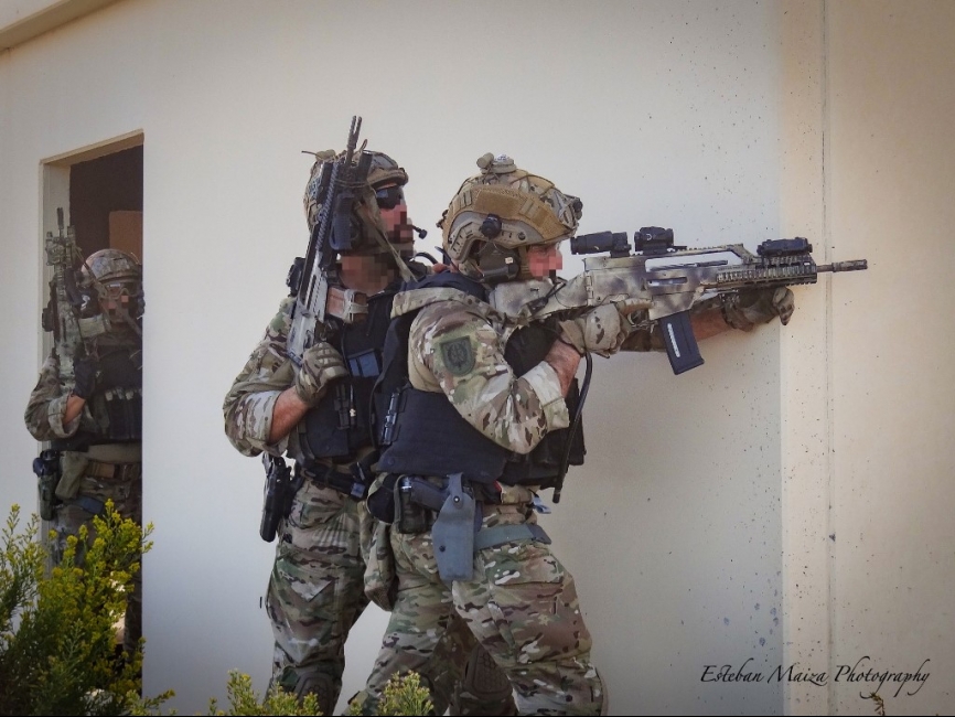 Operadores de un equipo del MOE cubriendo a sus compañeros que atienden a un herido en el interior de un inmueble.