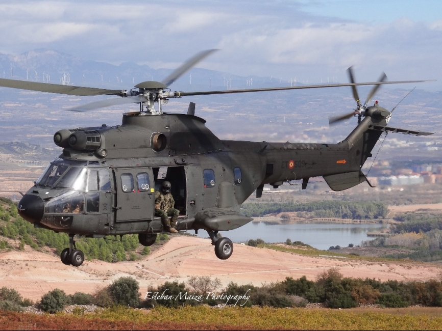UN Súper Puma del Batallón Cuartel General volando rumbo a una zona montañosa.