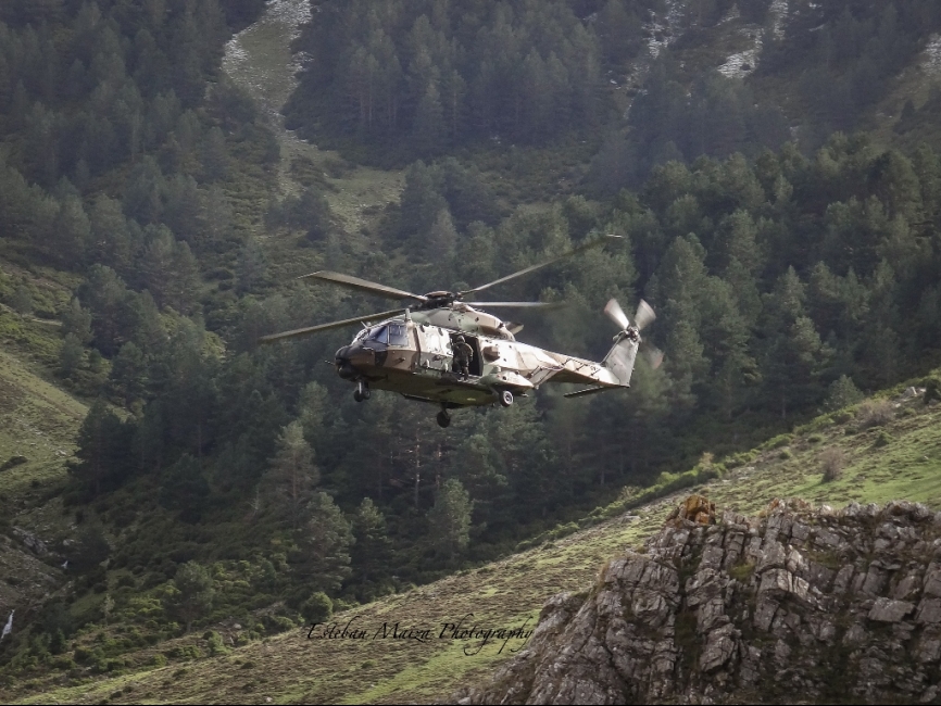 Un NH-90 ejecutando una aproximación por un valle a un punto de toma, maniobra muy exigente que requiere un procedimiento muy específico, condicionada por la orografía y en la que los pilotos deben una ruta de escape prevista en caso de abortar la maniobra.